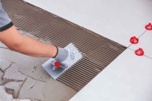 herramientas de acabado en la colocación de suelos como niveladores y llanas dentadas