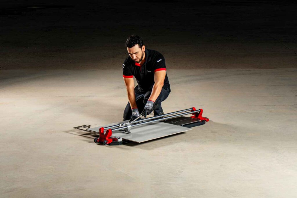 se presenta una persona realizando un corte de azulejo rectificado con máquinas cortadora manual de azulejos