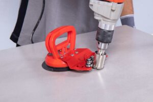 se muestra la guía para brocas y una broca diamantada haciendo un agujero en cerámica