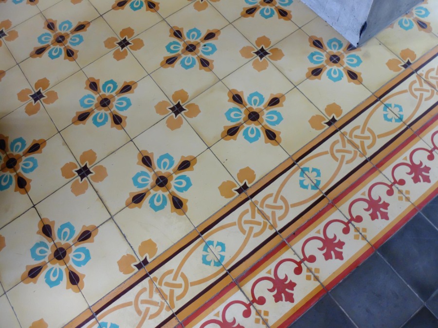 suelo hidraulico en baño colocado a la perfección de colores turquesa y amarillo pálido